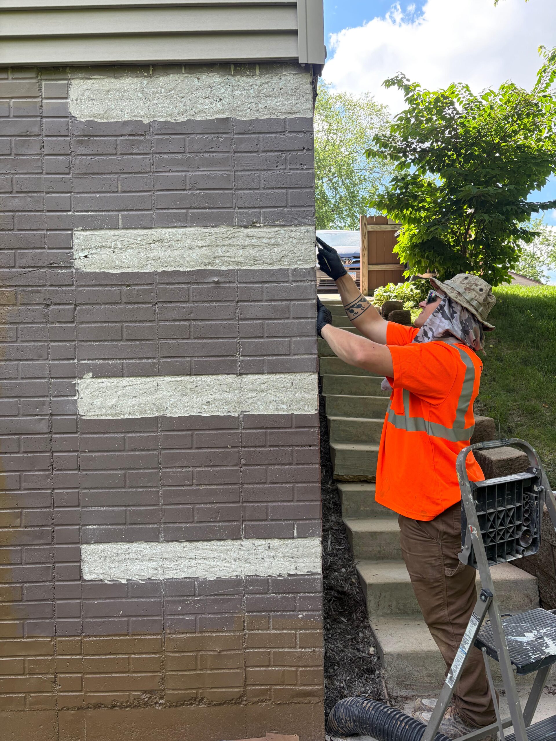 Behncke Construction crew member sealing a foundation crack from the exterior