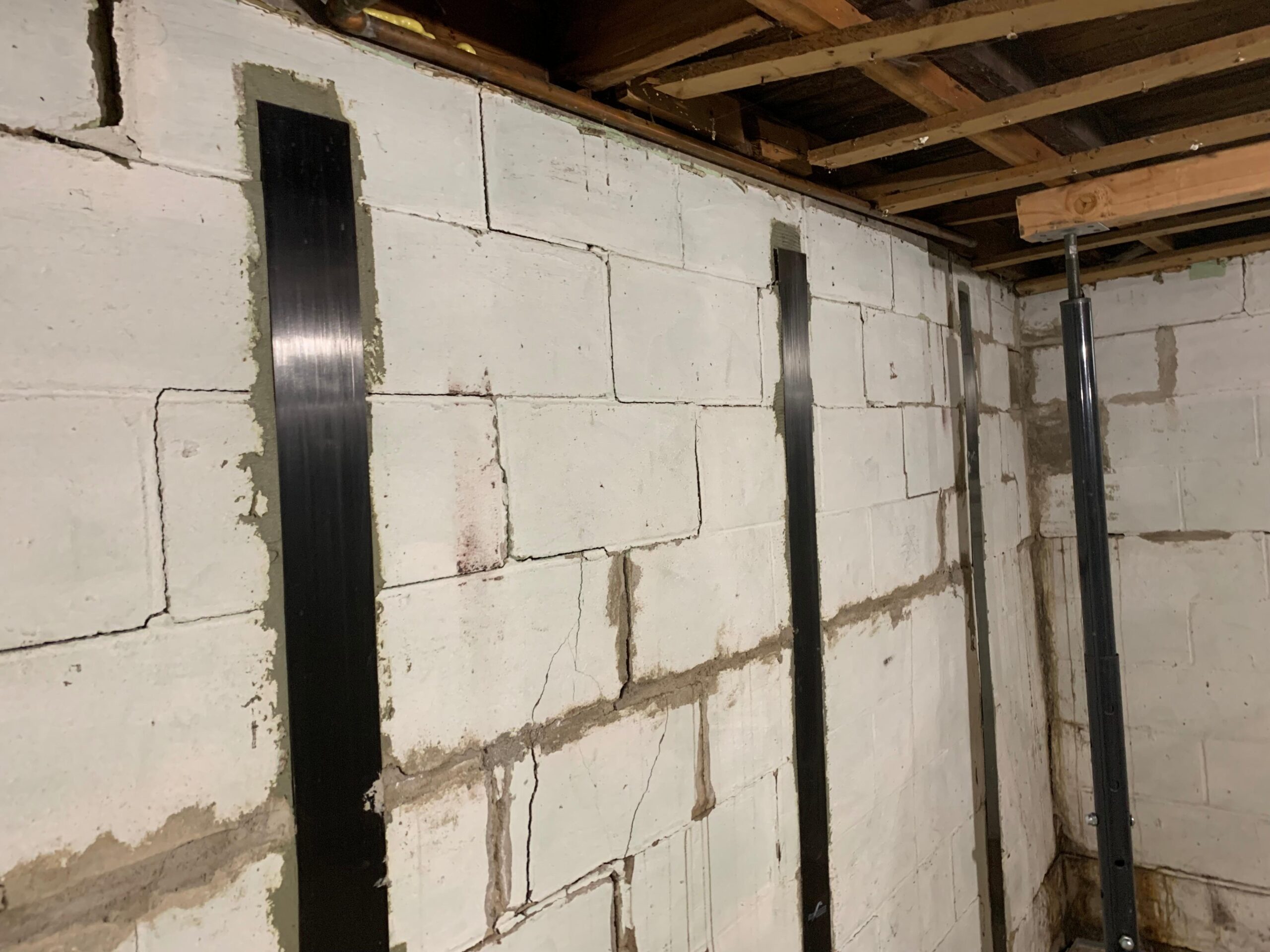 Stair-step and horizontal cracking across a block basement wall in the Quad Cities