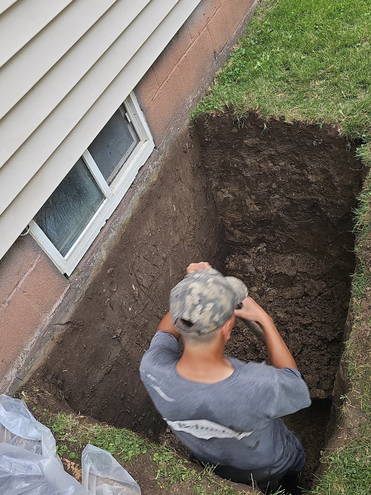 Hand-dug excavation during egress window installation in Rock Island, Illinois