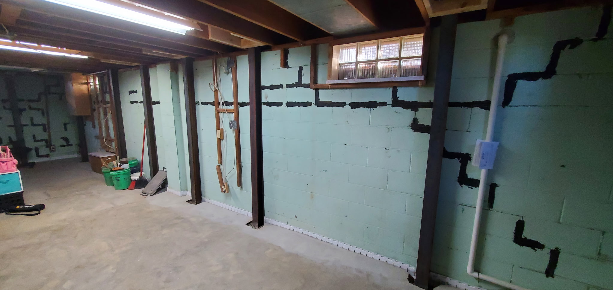 Basement wall covered in patched stair-step cracks that kept returning