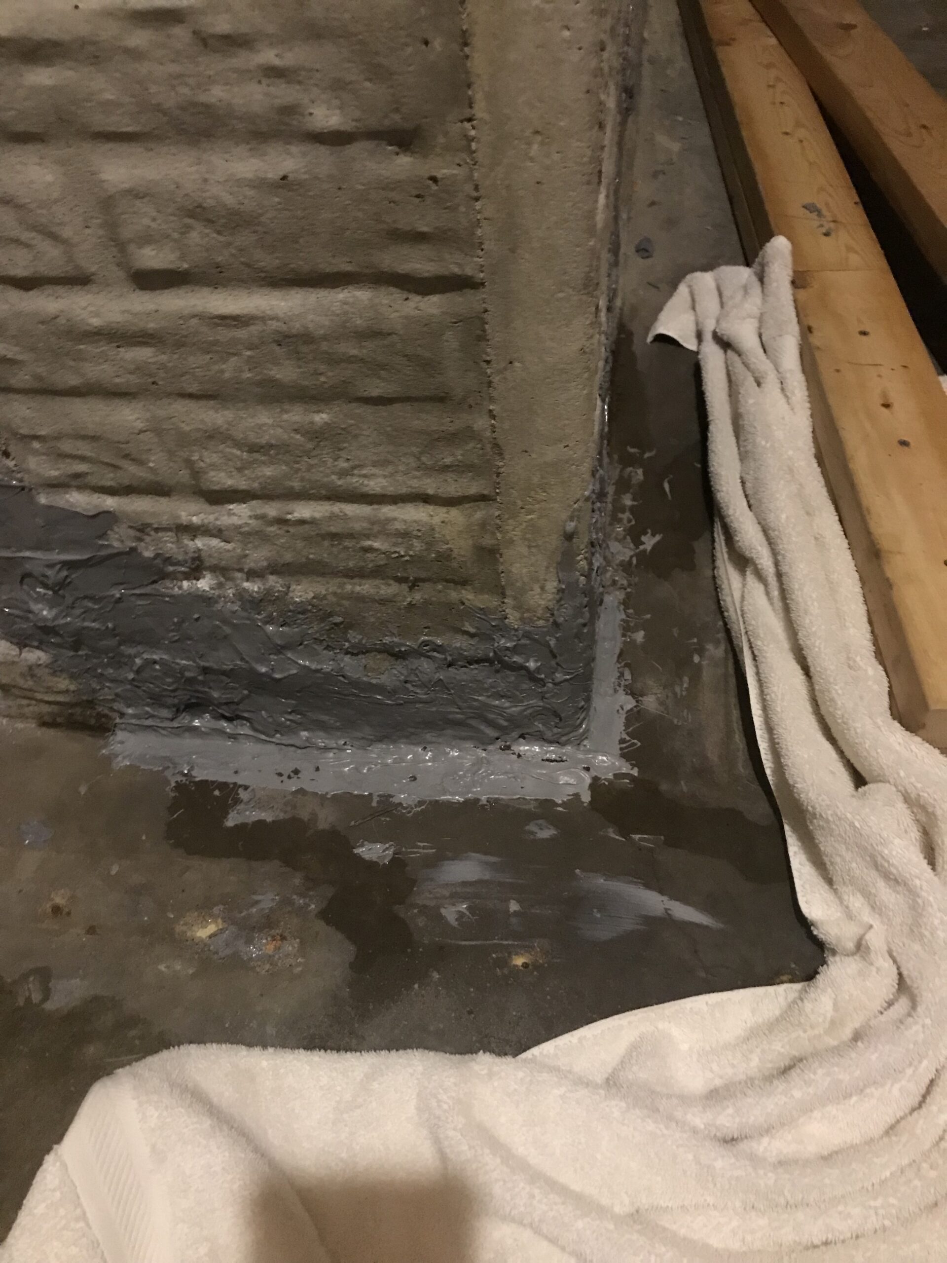 A sealed crack in a poured concrete foundation corner