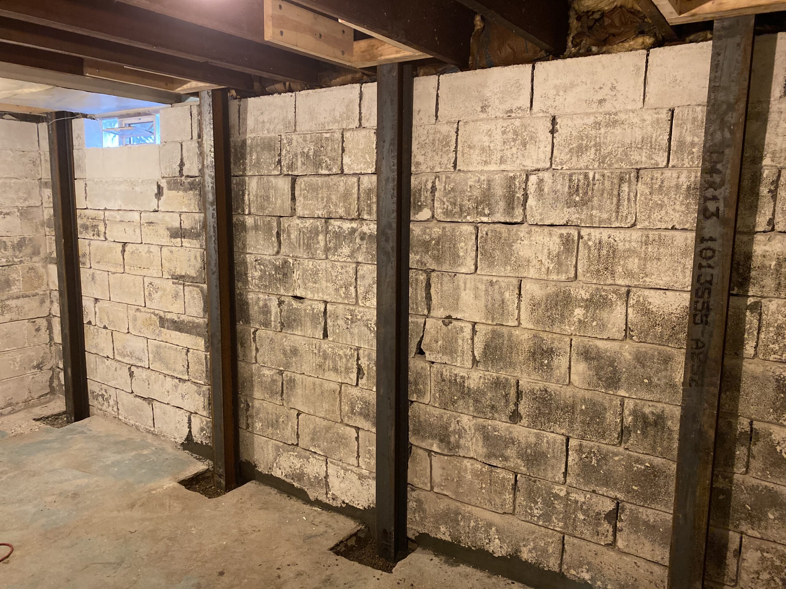 Cracked block basement wall with steel reinforcement, the kind of finding a foundation inspection surfaces