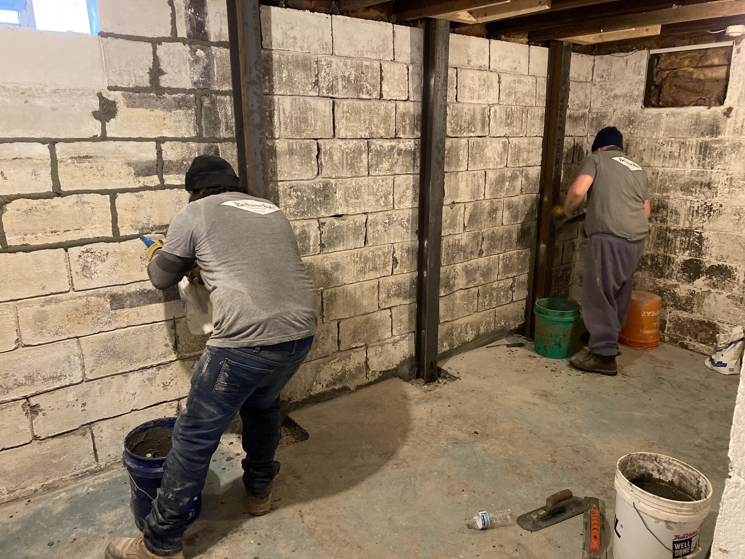 Behncke Construction crew repairing a heavily cracked block basement wall