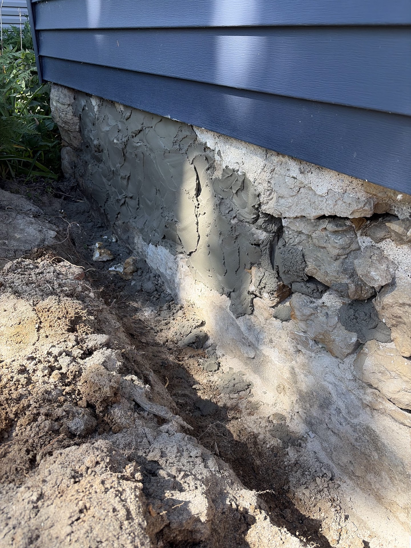 Deteriorated stone foundation with open mortar joints before repair, Davenport IA