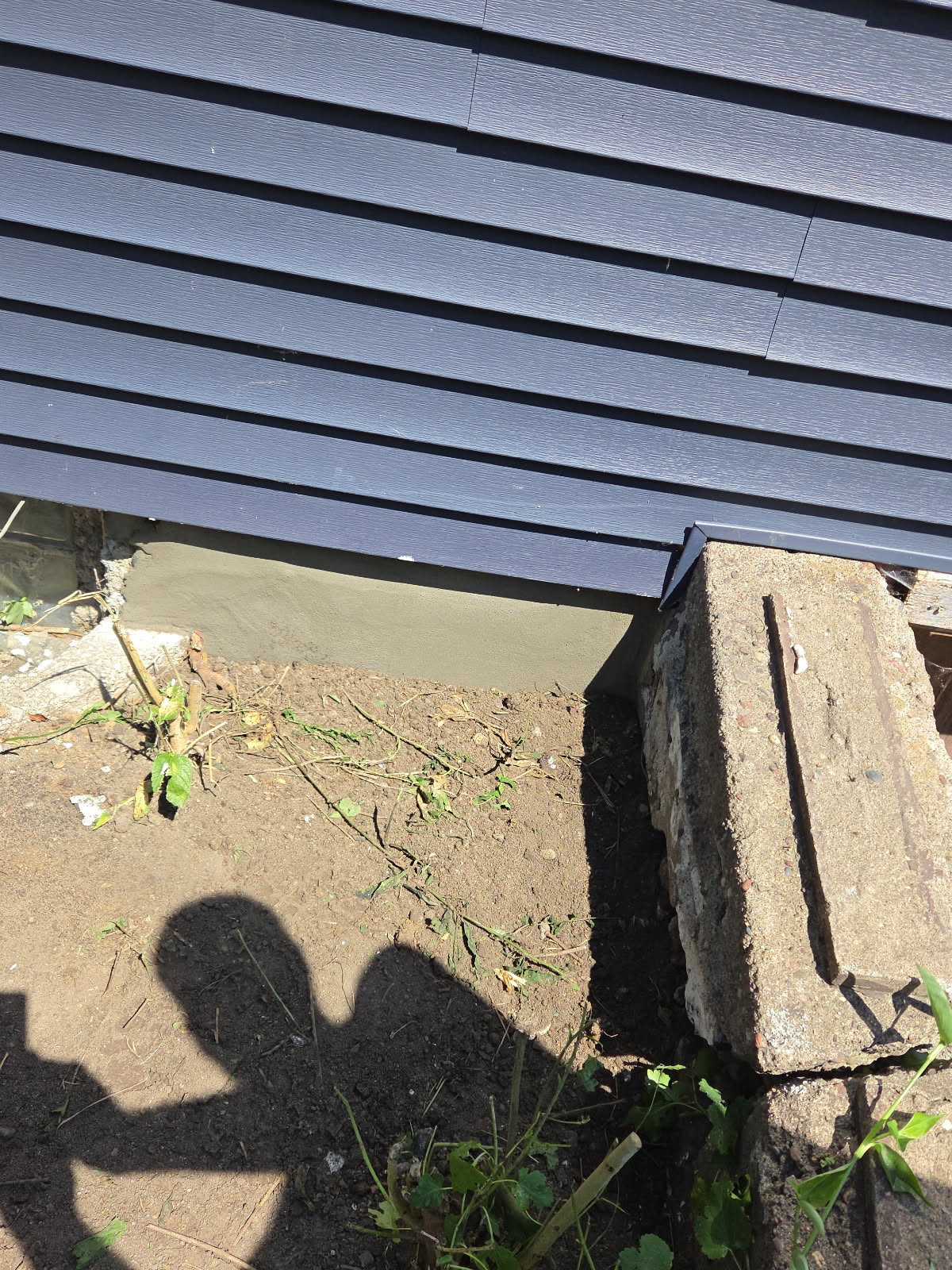 Smooth finished parge coat at the base of the foundation wall, Davenport IA