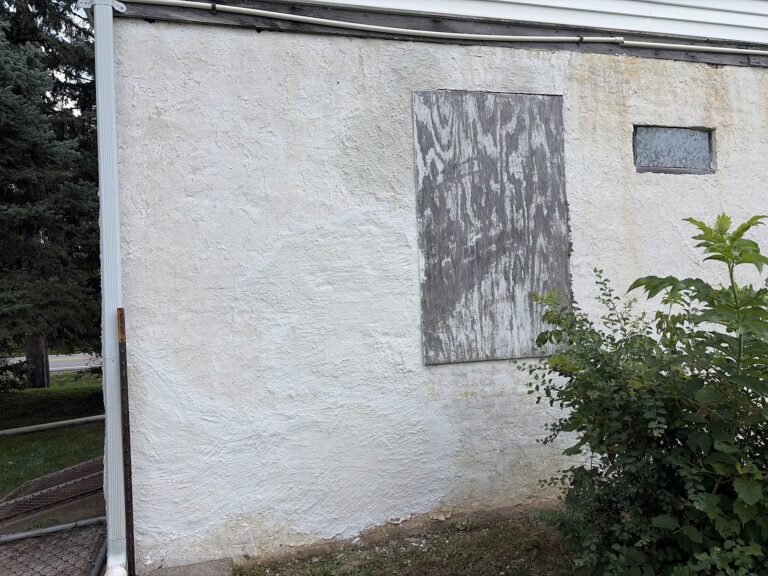 Completed exterior stucco repair on a Bettendorf, Iowa home — the restored wall now carries a uniform surface bonding cement finish that blends with the existing exterior