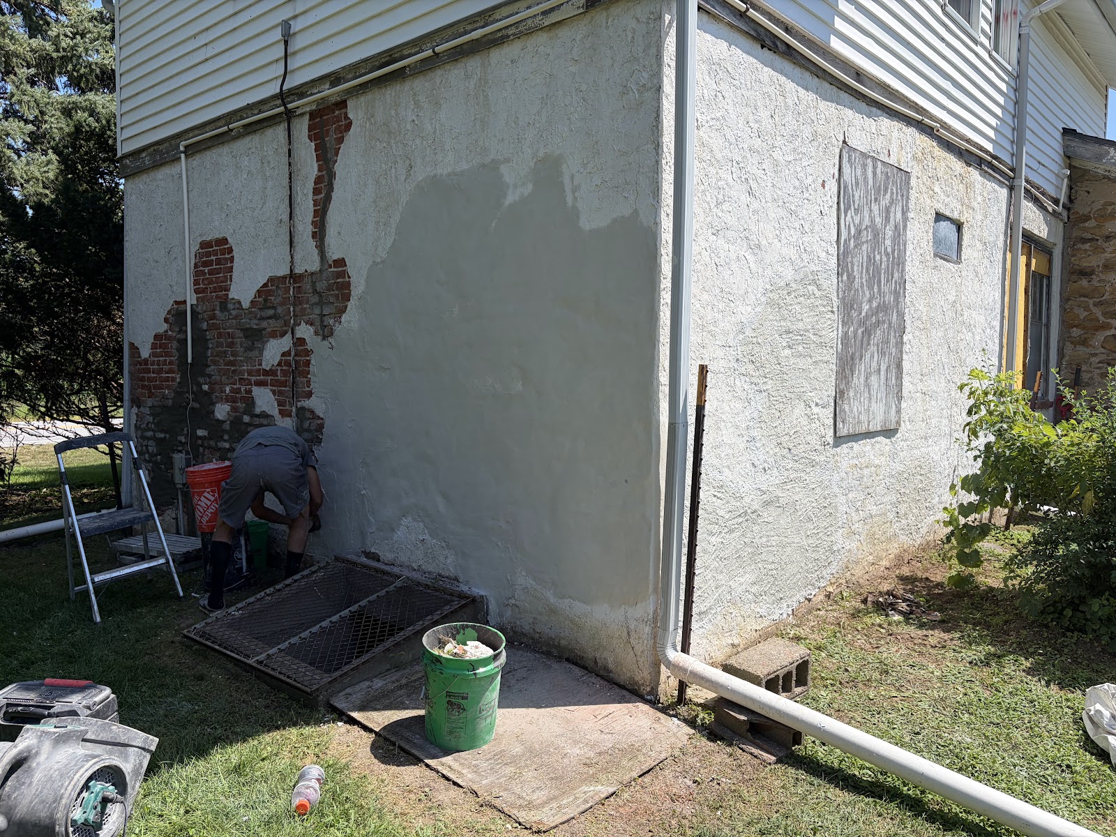 Behncke Construction crew applying premium surface bonding cement to the prepared wall during the Bettendorf stucco repair