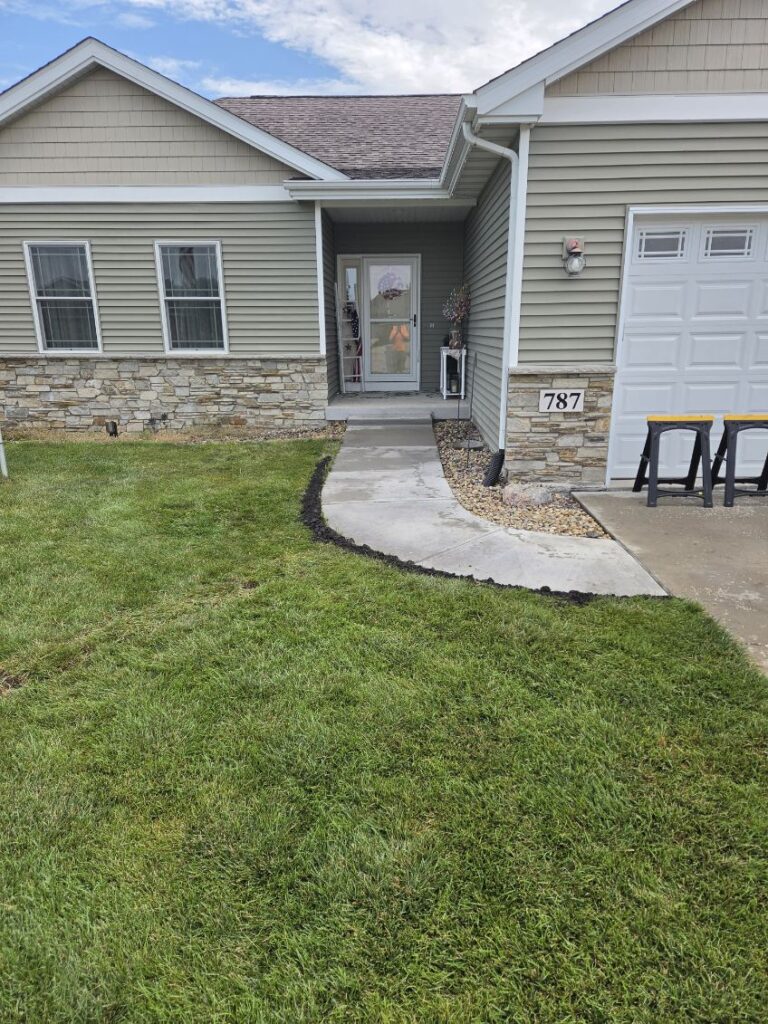 New concrete sidewalk and repaired front entrance at a home in Blue Grass, Iowa