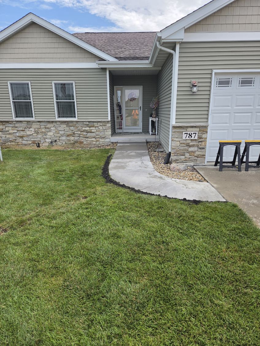 New concrete sidewalk and repaired front entrance at a home in Blue Grass, Iowa