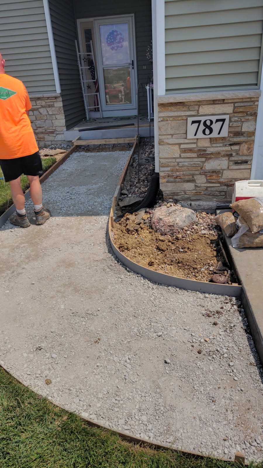 Freshly poured concrete sidewalk section with gravel edging