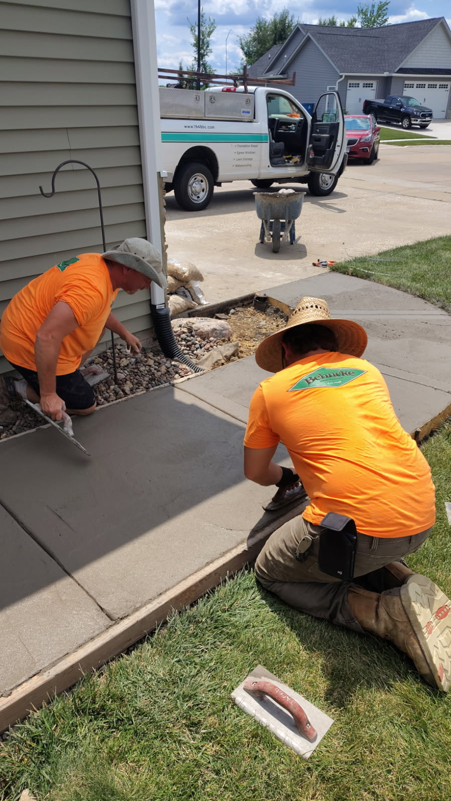 Finishing new concrete flatwork during a sidewalk replacement