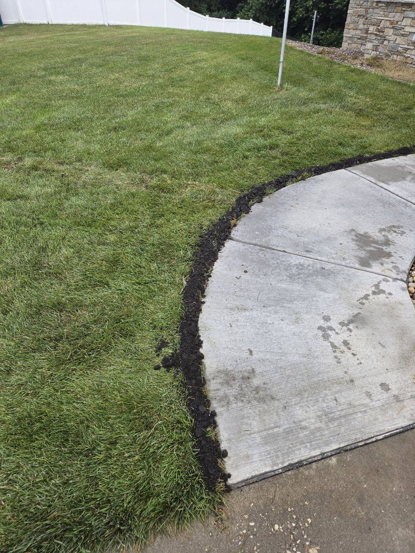 Curved concrete sidewalk finished next to the yard