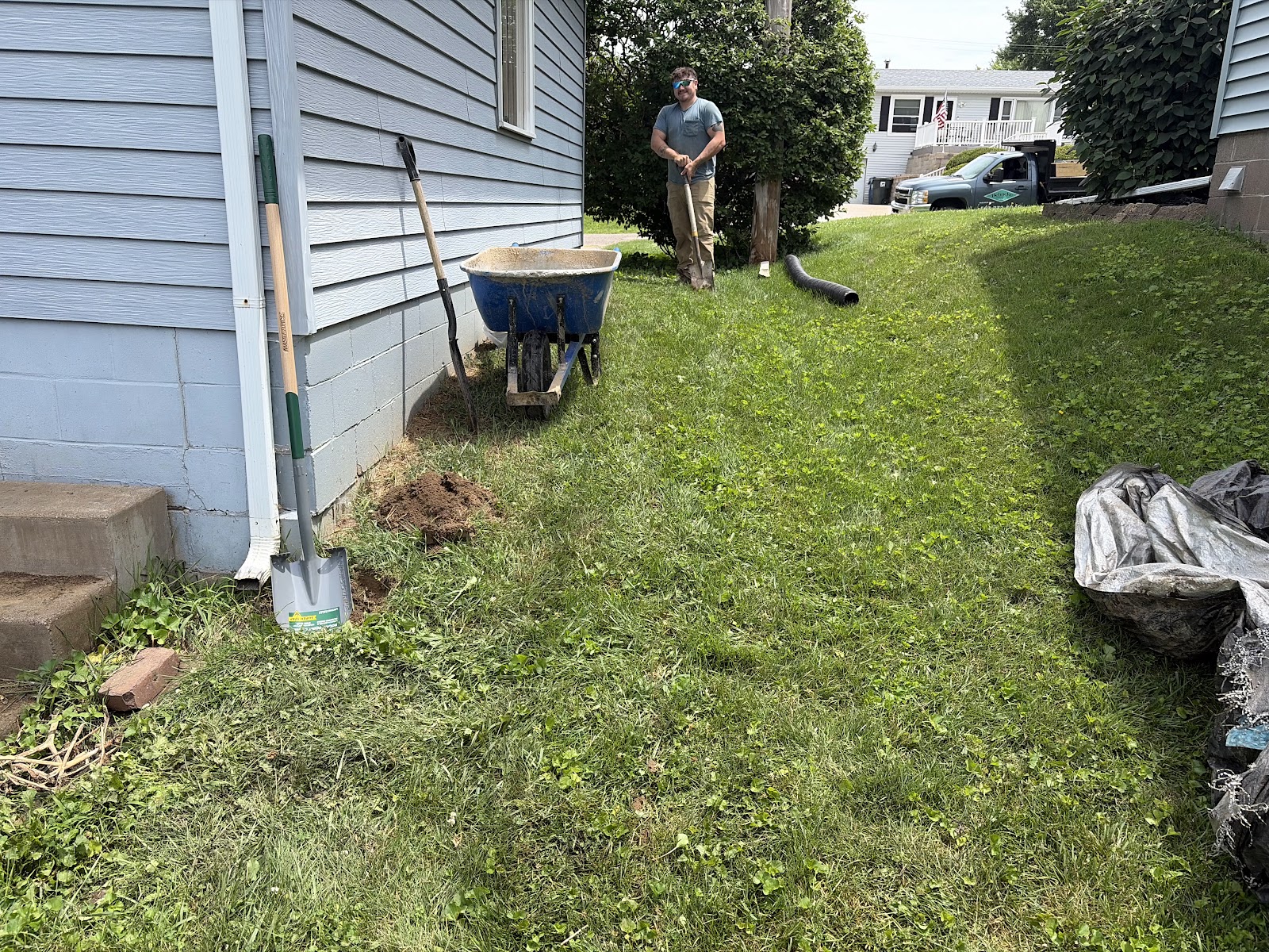 Underground downspout drain line being installed across the yard to carry roof water away from the foundation