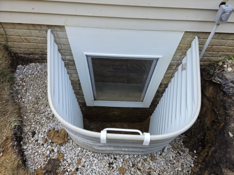 Rebuilt egress window well set to the correct depth with clean drainage stone in Bettendorf, Iowa
