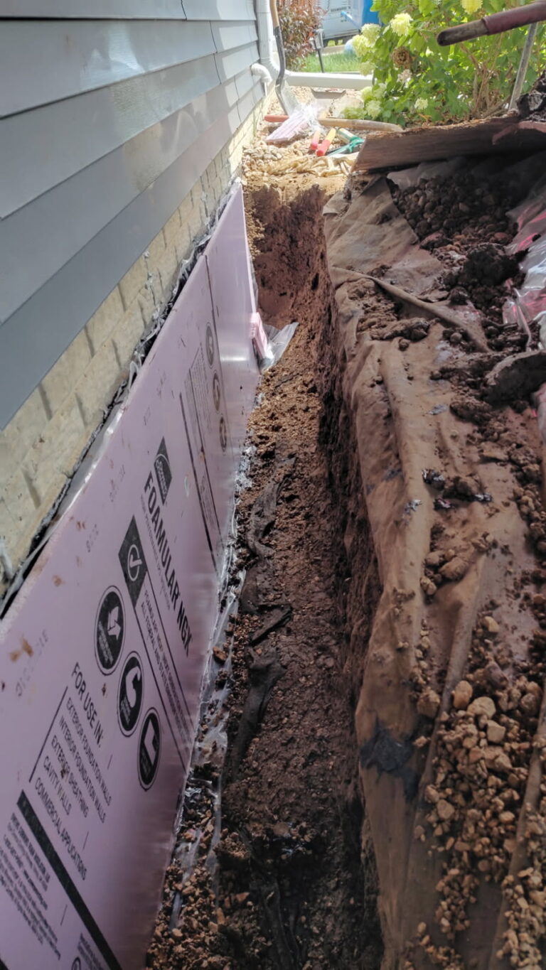 Exterior excavation exposing a poured concrete foundation wall for crack repair in Davenport, Iowa