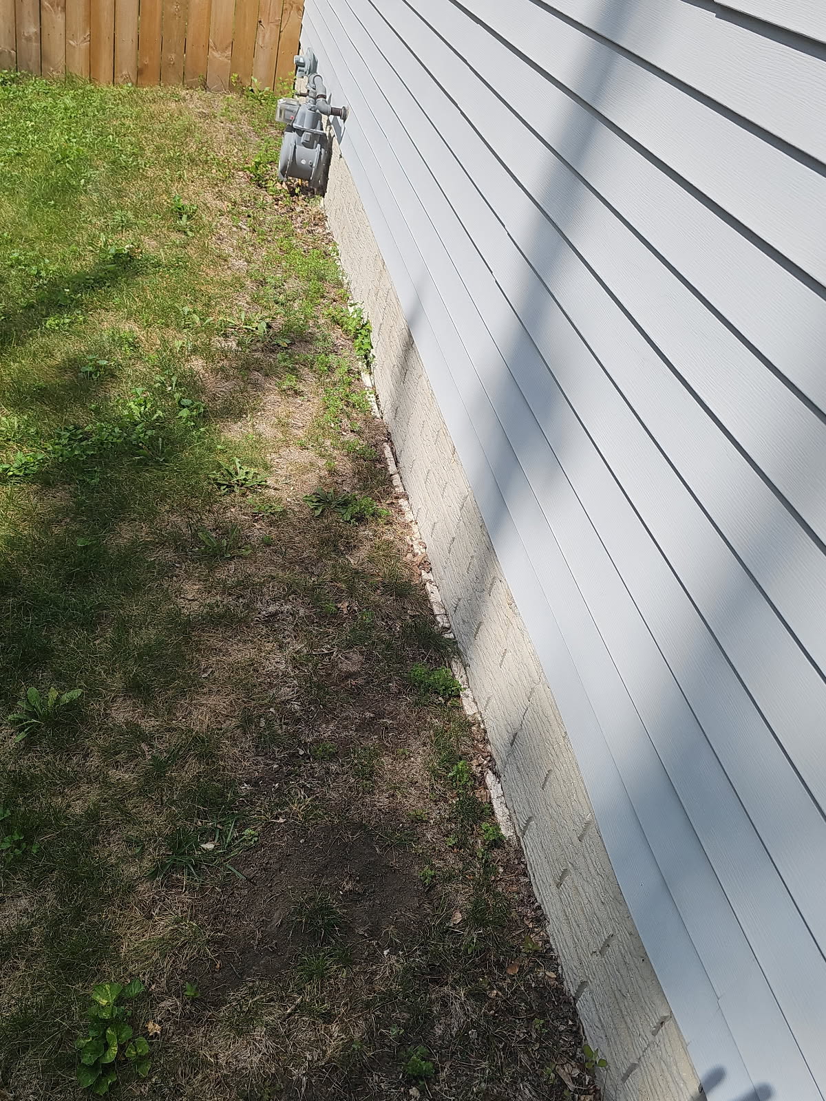 Exterior of the poured concrete foundation wall during crack sealing