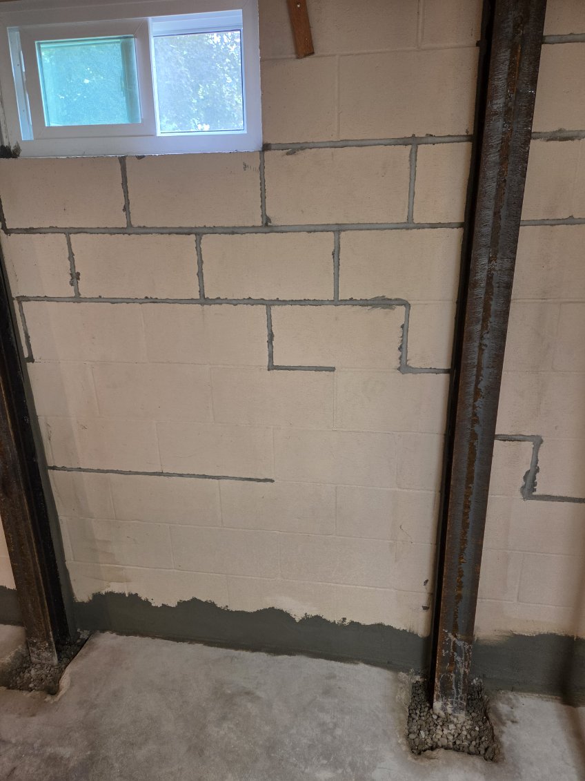 Braced concrete block foundation wall with repaired mortar joints