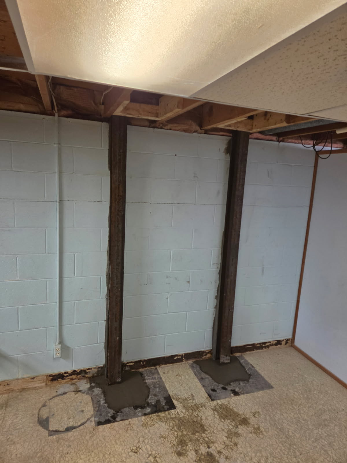Row of steel I-beams stabilizing the bowing basement wall