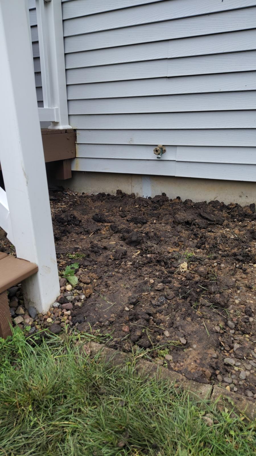 Backfilled ground alongside the house after the exterior foundation crack repair was completed