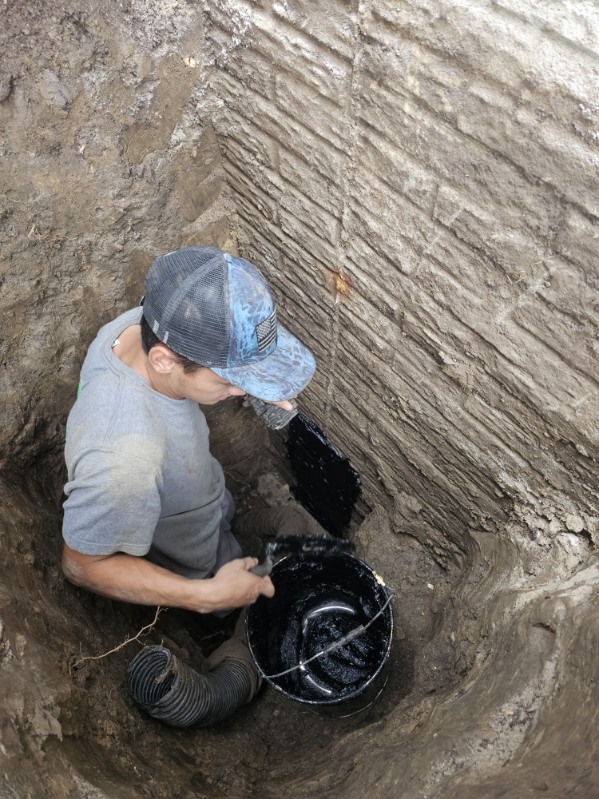 Working on the foundation wall from inside the open excavation