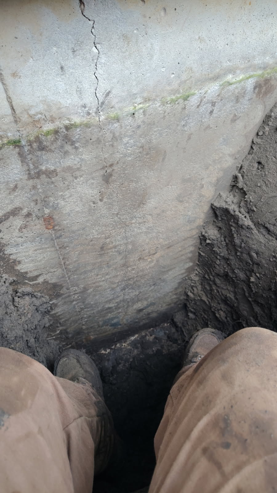 Close view of the vertical foundation crack on the exposed exterior wall face