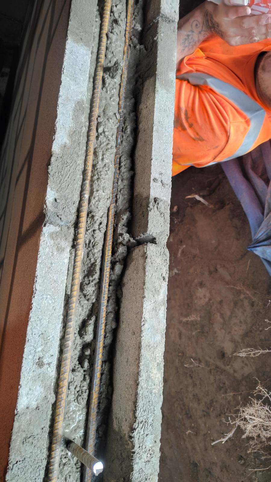 Vertical reinforcing steel set inside a block cavity before grouting
