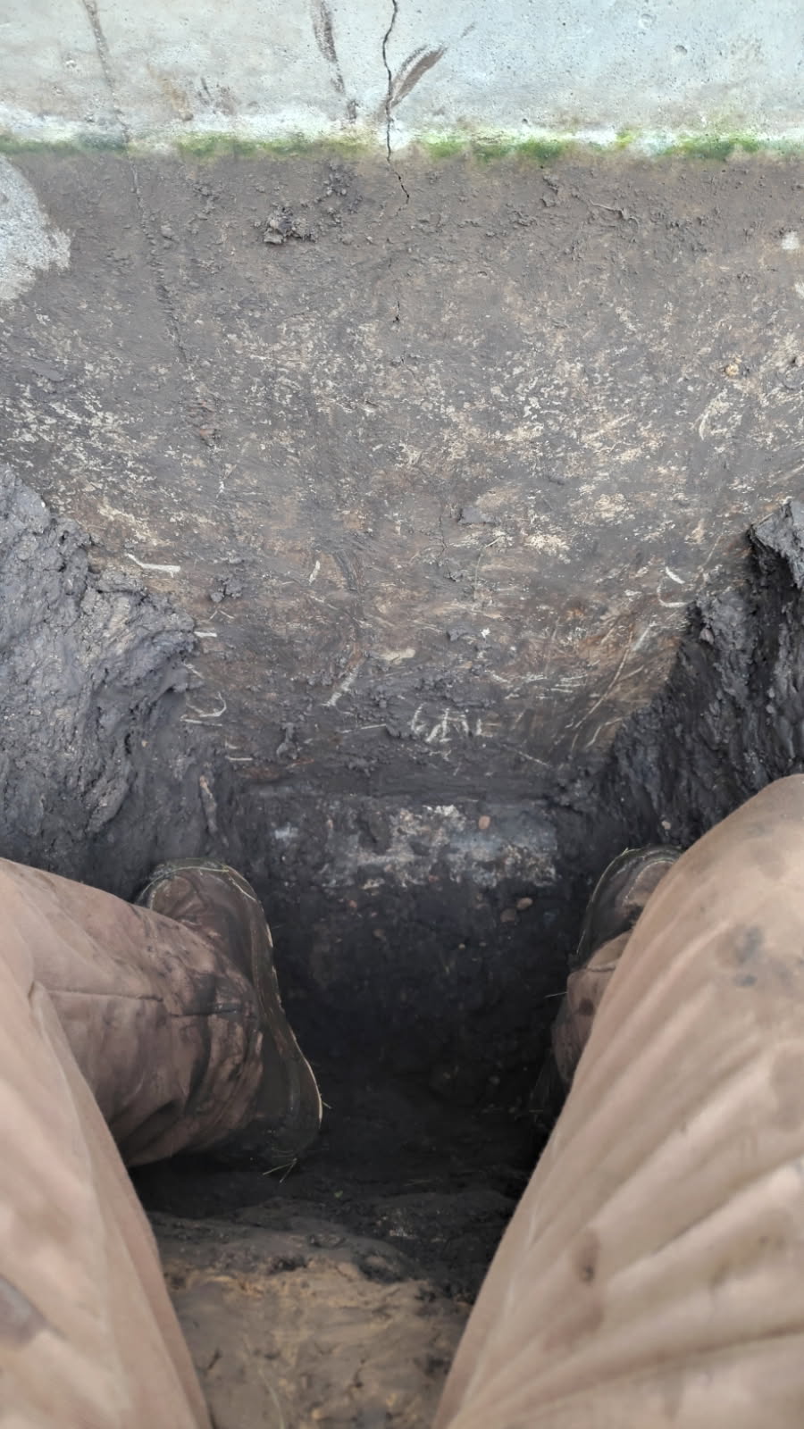Excavated exterior foundation wall with the vertical crack exposed for repair