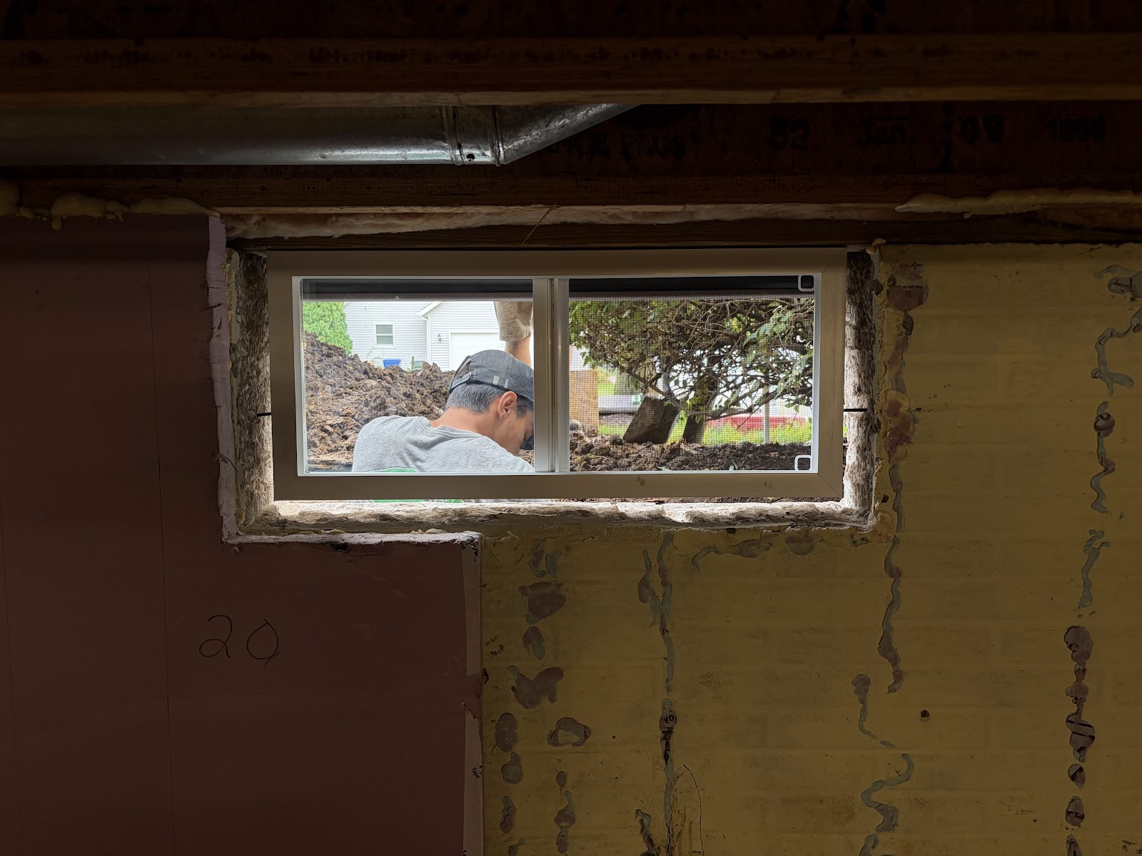 Interior view of a new double-sliding basement window set into the masonry opening