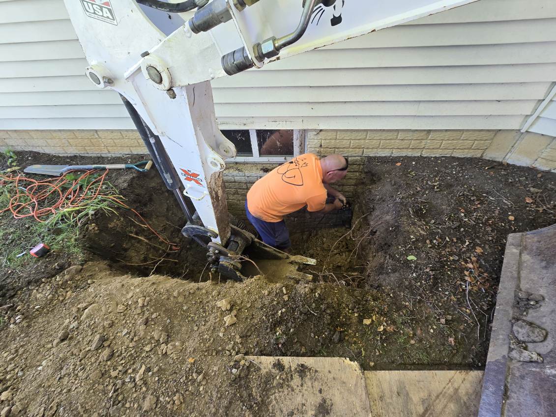 Excavation beside the foundation for a new egress window opening in Davenport, Iowa