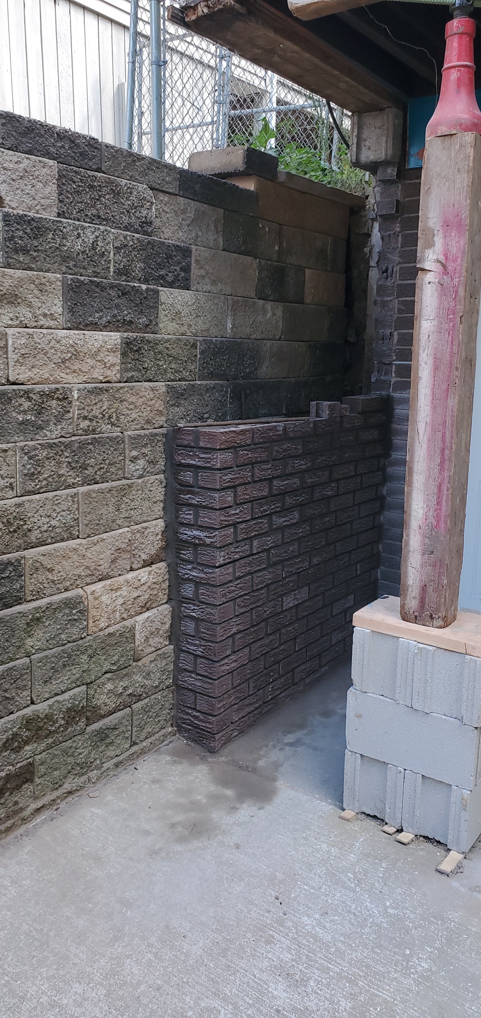 Rebuilt retaining wall section tied into the existing stone wall