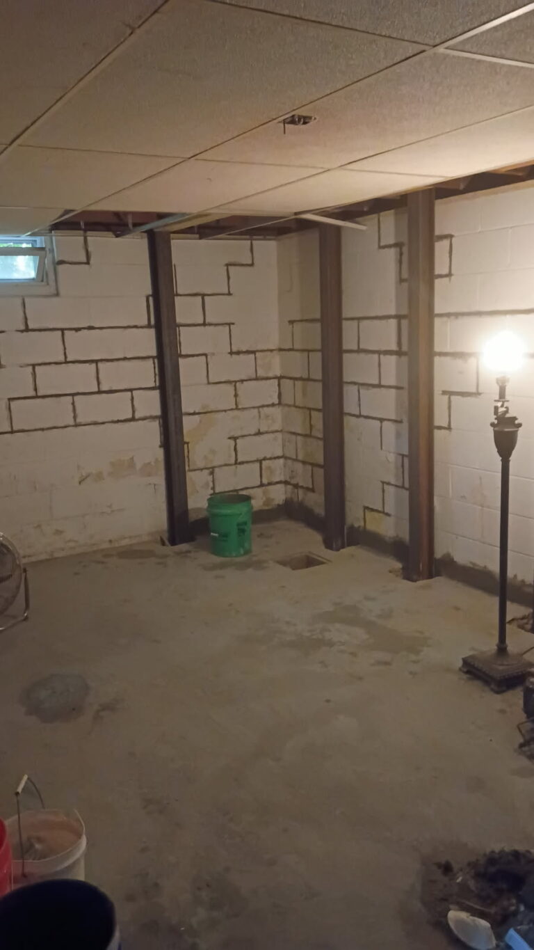 Finished basement with steel I-beam braces installed along the block foundation walls in Moline
