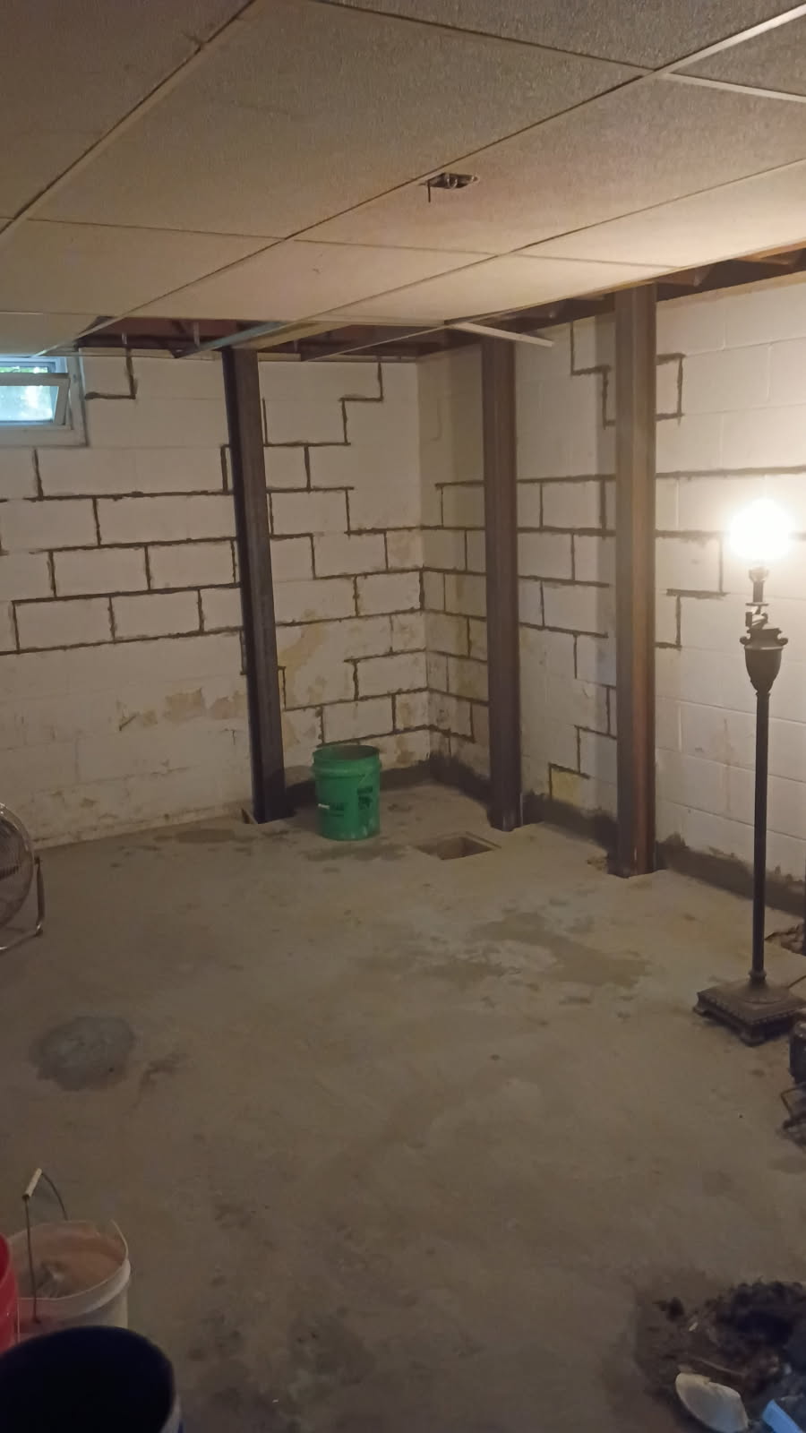 Finished basement with steel I-beam braces installed along the block foundation walls in Moline