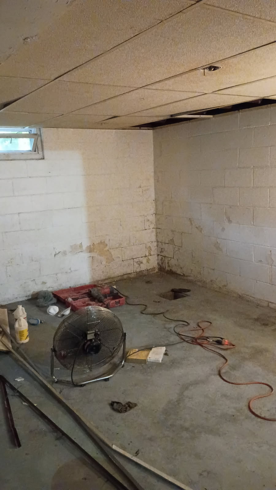 Block foundation wall before the work, with staining and open mortar joints along the base