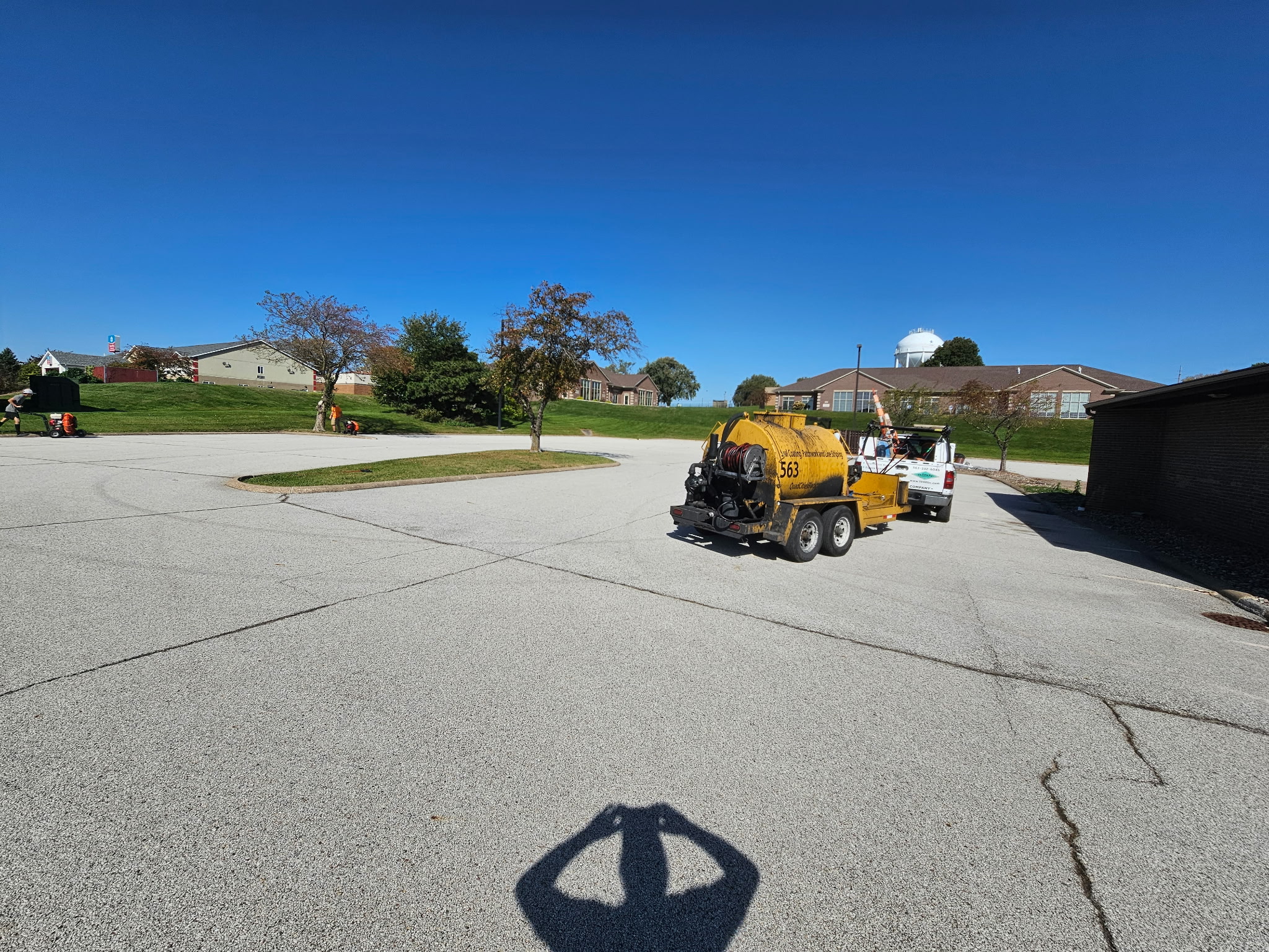 Behncke sealcoating rig and crew truck on the Bettendorf parking lot