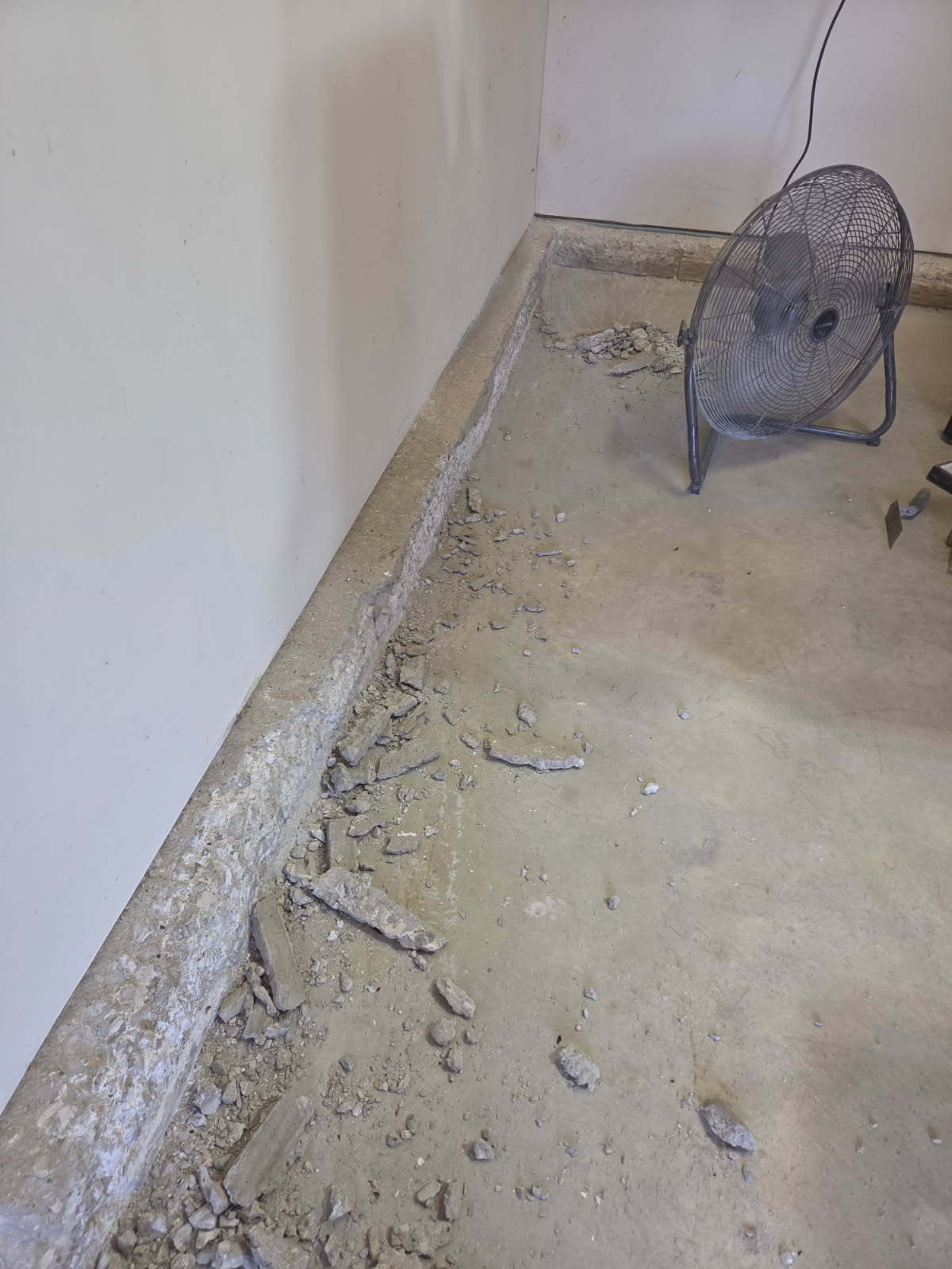 Deteriorated stem wall surface along the garage floor before repair