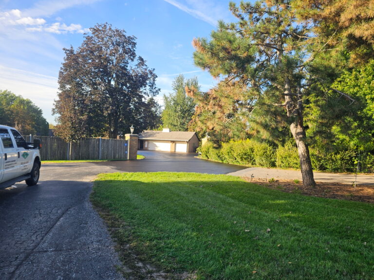 Freshly sealcoated asphalt driveway near Port Byron with a uniform black finish