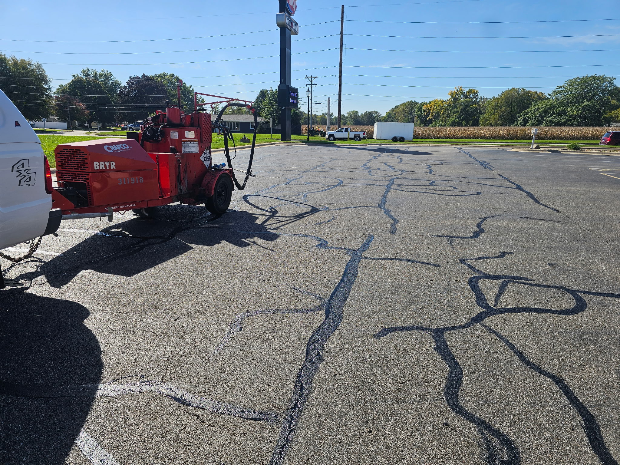 Hot rubberized crack sealant applied across cracks in the Bettendorf parking lot before sealcoating