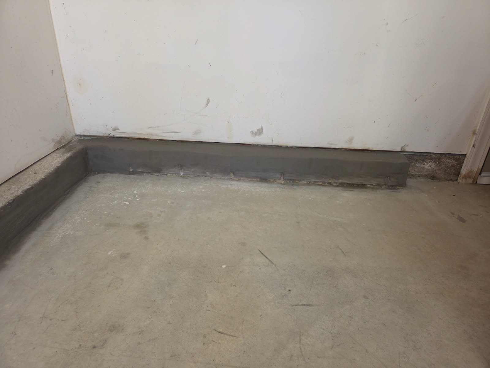 Repaired stem wall along the garage floor