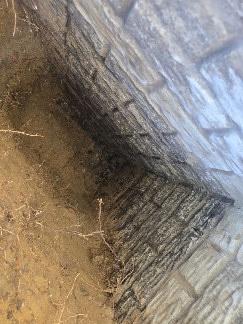 Exterior excavation taken down along a Bettendorf foundation wall to expose a leaking crack