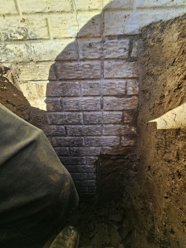 Exterior excavation exposing the foundation crack from top to bottom