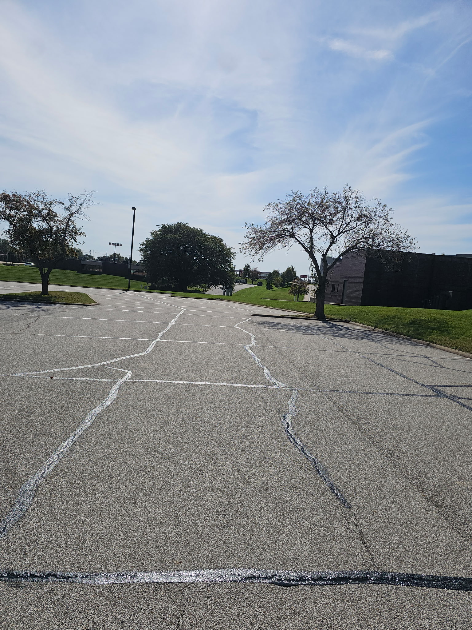 Crack-filled asphalt parking lot in Bettendorf with sealed cracks visible before sealcoating
