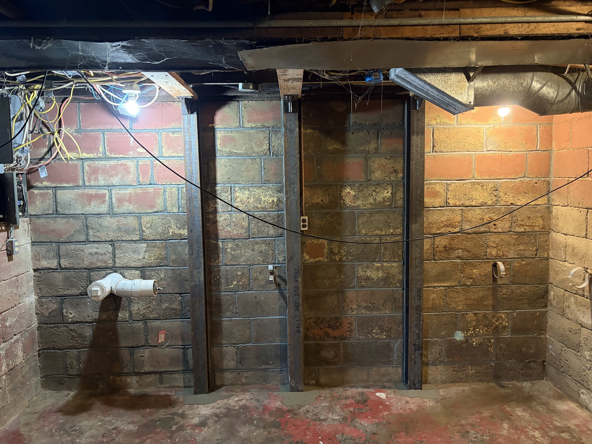 Block foundation wall in Port Byron stabilized with heavy-duty steel braces and gussets