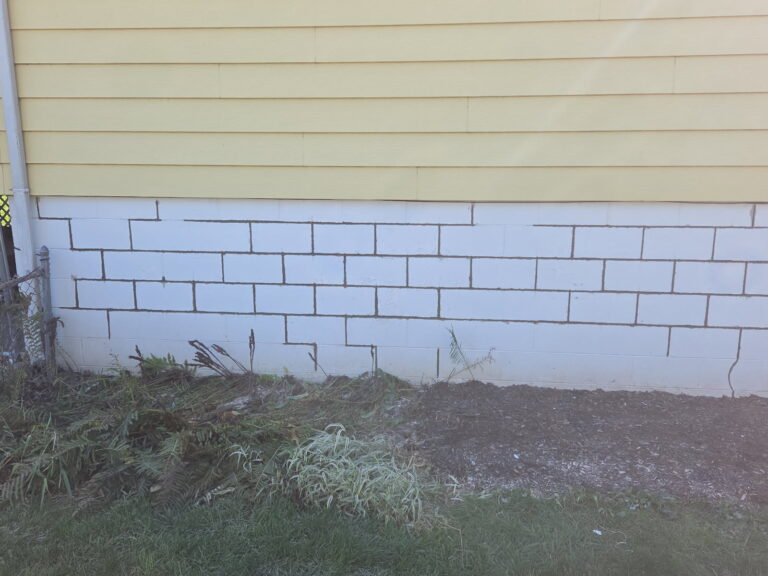 Block foundation with freshly tuckpointed mortar joints below the siding in Moline