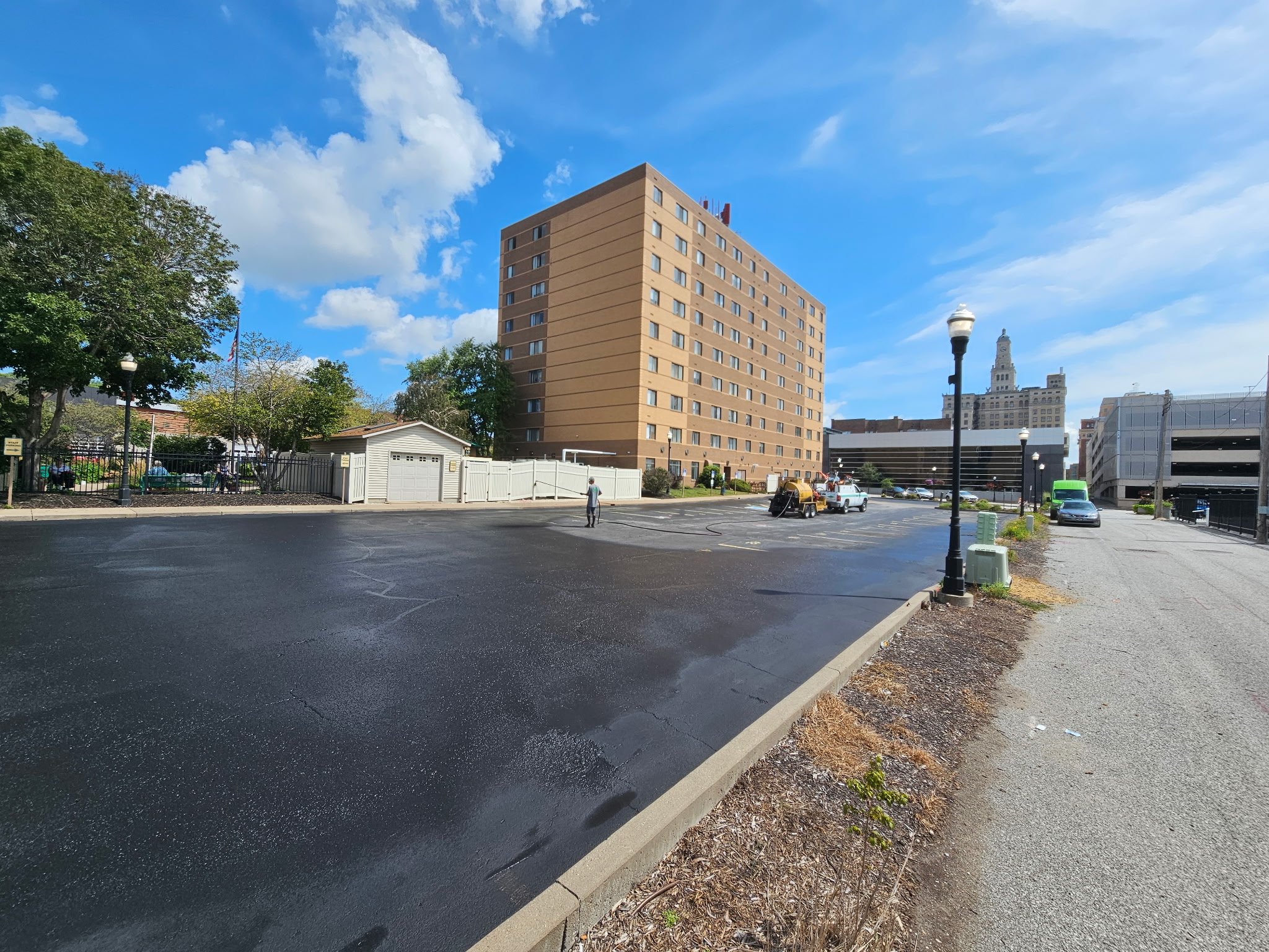Freshly sealcoated downtown Davenport parking lot beside a multi-story building