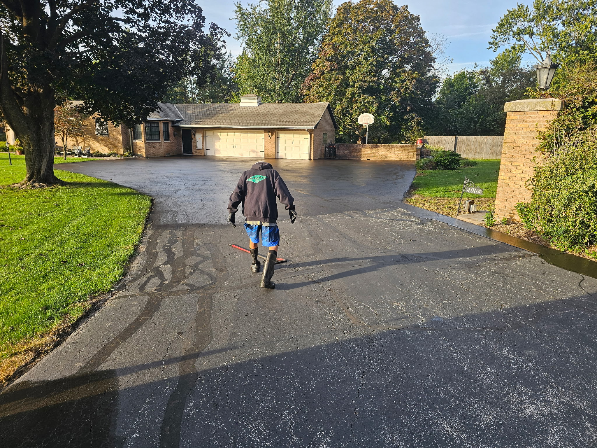 Crew member applying sealer along the driveway during the project
