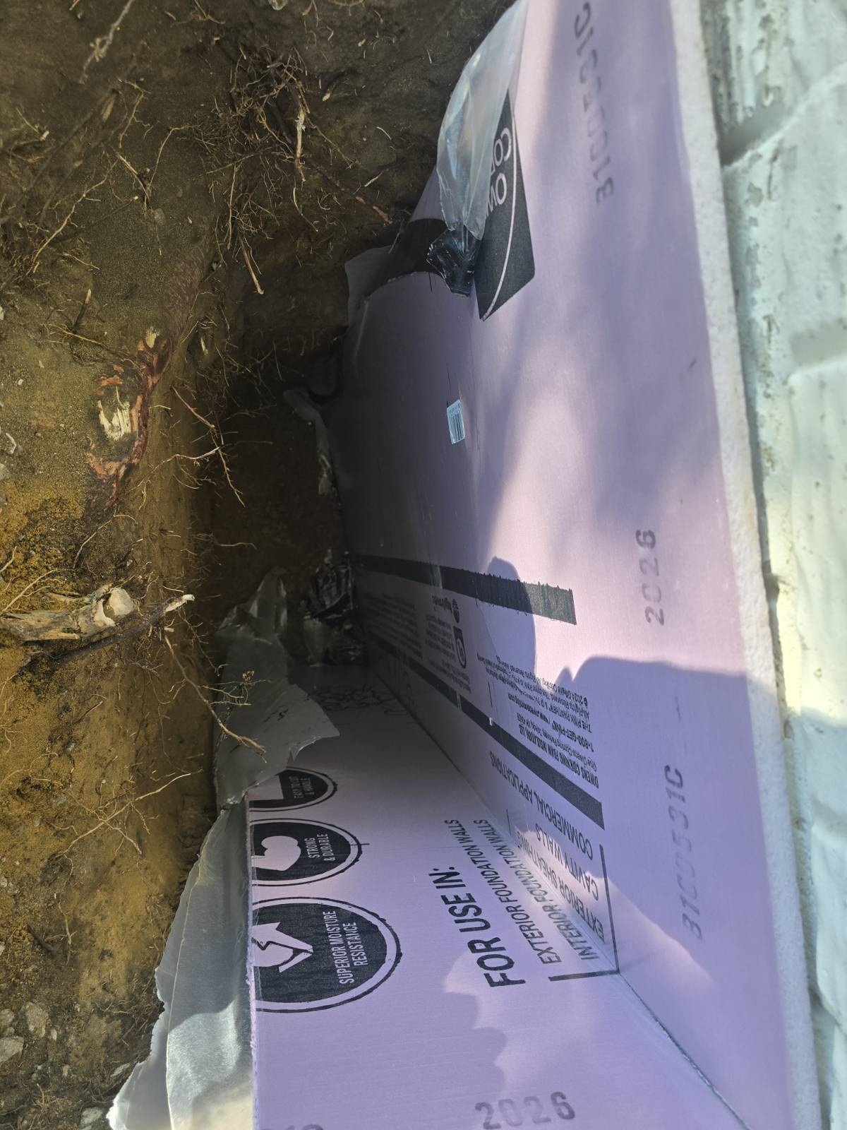 Protective sheeting placed against a sealed foundation wall in Bettendorf before backfill