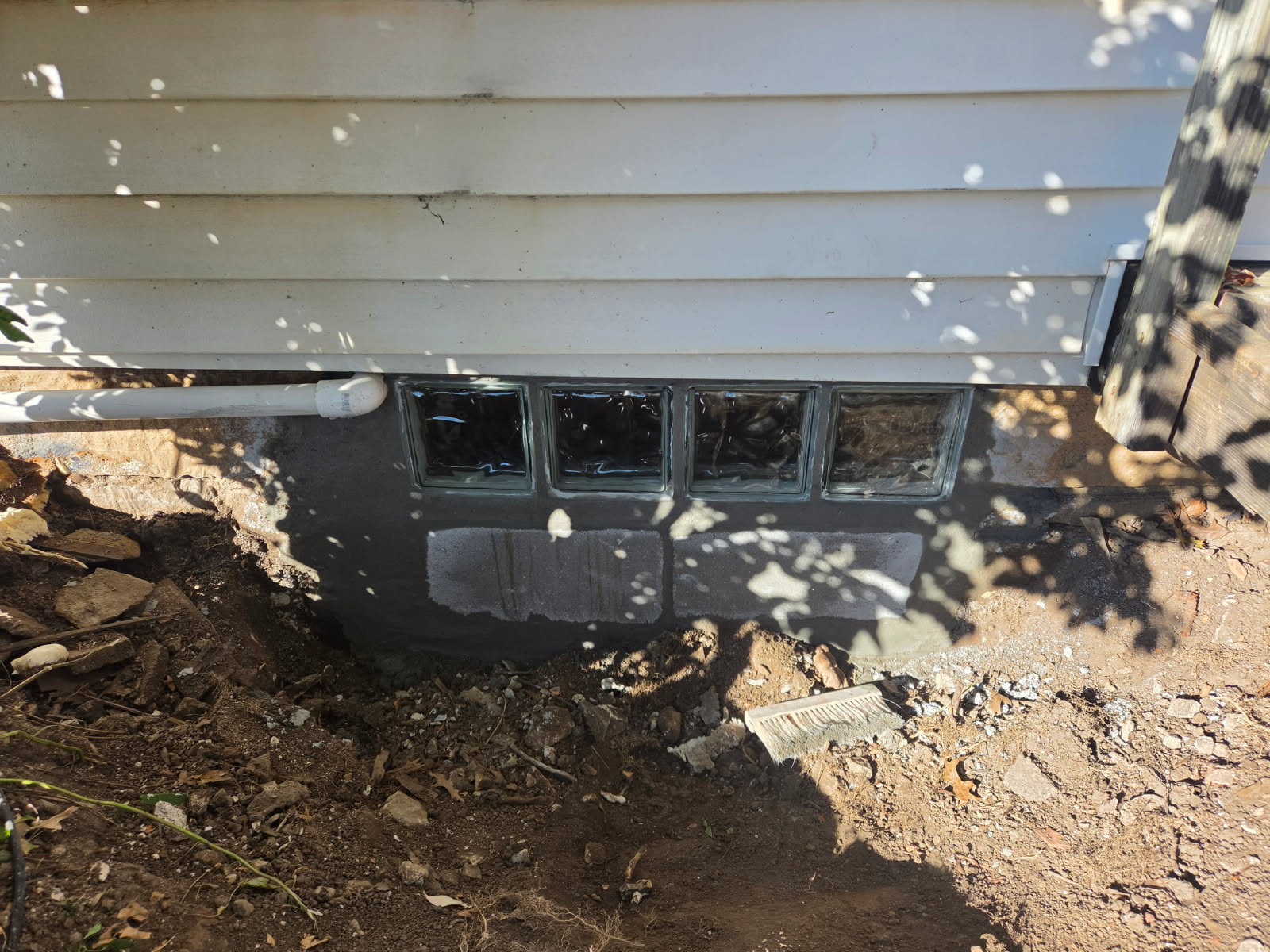 Glass block basement window being set at the exterior of a Davenport home