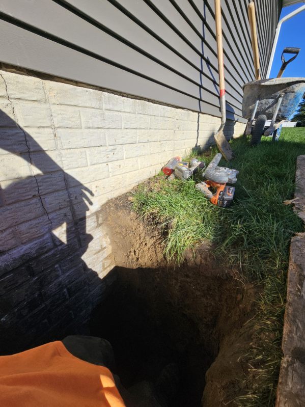 Block foundation wall sealed from the exterior with the excavation beside it in Bettendorf