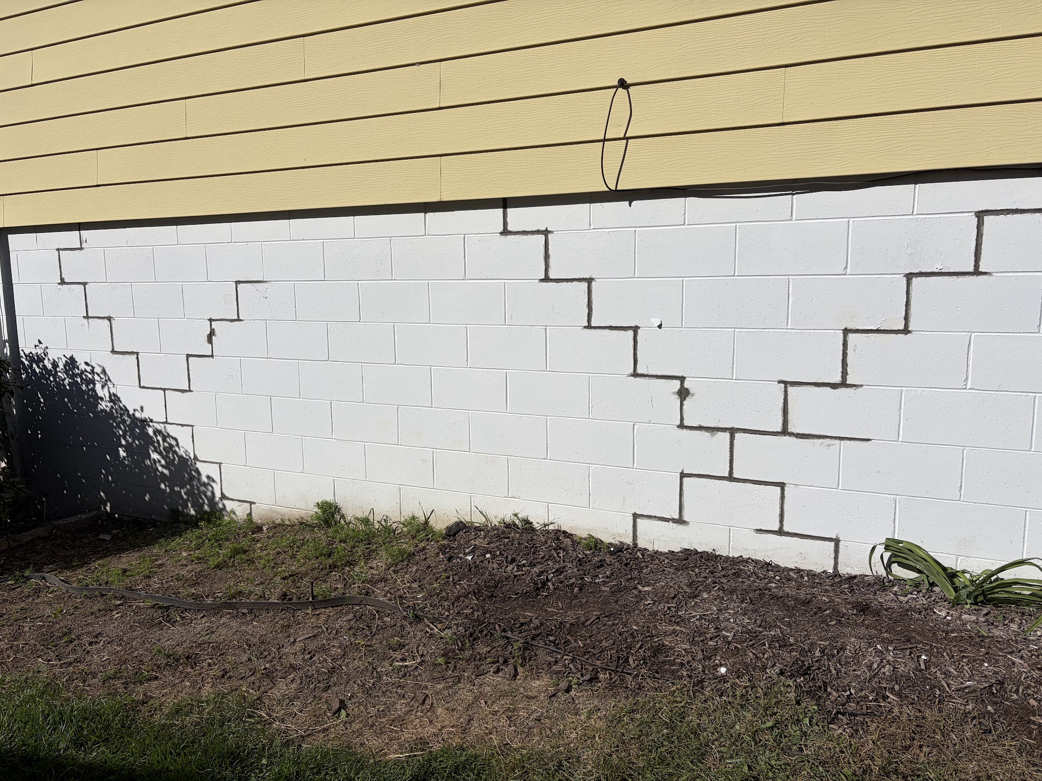 Deteriorated and broken mortar joints in the block foundation before tuckpointing